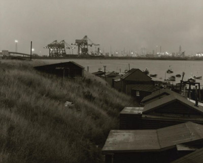 Tees Estuary: Cabins at Paddy’s Hole looking towards the B.S.C. Ore off-loading cranes. A wet dusk in late summer, c. 1980